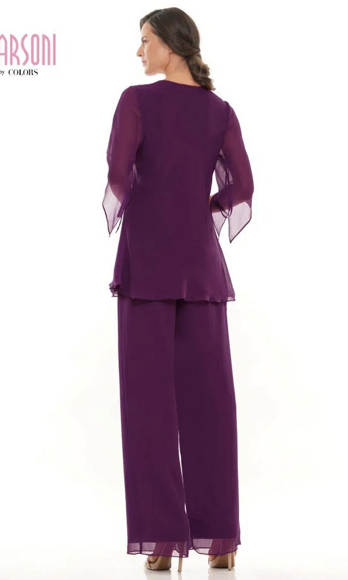A woman stands facing away, wearing the Marsoni M308 Long Formal Pantsuit—a loose-fitting, deep purple chiffon ensemble with sheer sleeves and matching wide-leg pants.
